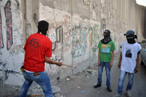 Palestinians seen breaking a piece of the separation wall in the city of Abu Dis, near Ramallah. (Photo: Sliman Khader/Flash90)