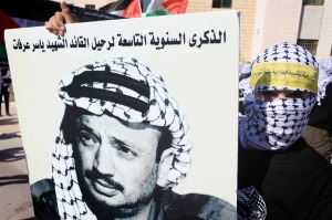 A masked Palestinian with Arafat's poster. (Issam Rimawi/Flash90)