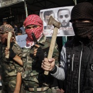 Masked Palestinians hold axes and a gun to celebrate the Jerusalem synagogue attack. (Abed Rahim Khatib/Flash90)