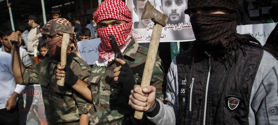Masked Palestinians hold axes and a gun to celebrate the Jerusalem synagogue attack. (Abed Rahim Khatib/Flash90)