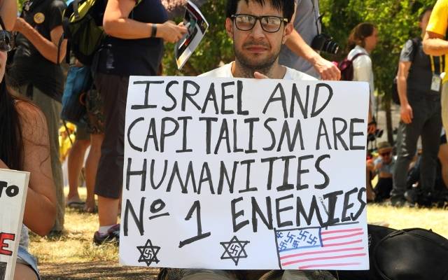 A demonstrator invokes Nazi imagery in his anti-Israel "protest." (Shutterstock)