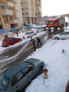 Fire department in Efrat hoses down the snow in an attempt to clear the road. Photo: Daniel Sass
