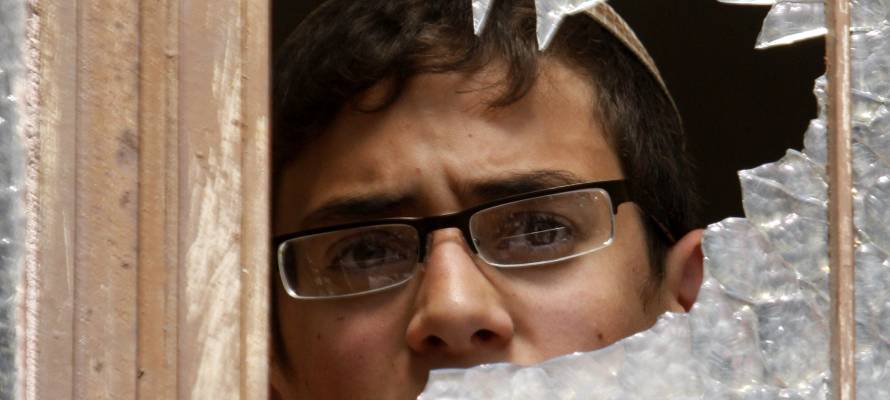 Jewish man peers through broken window. (Photo: Nati Shohat/Flash90)
