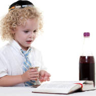 A Jewish boy recites the prayer over grape juice. (Photo: Geo Martinez/Shutterstock)