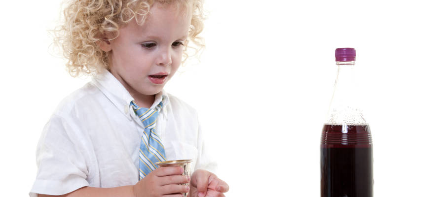 A Jewish boy recites the prayer over grape juice. (Photo: Geo Martinez/Shutterstock)