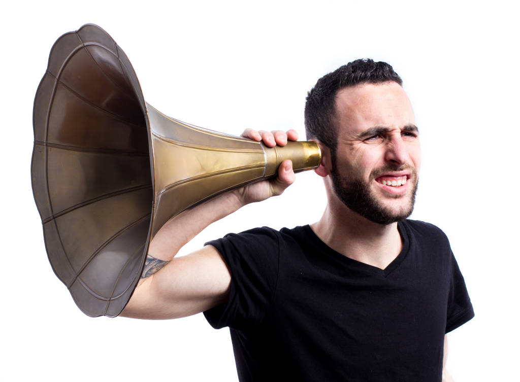 Man tries to hear with old-fashioned hearing aid. (Photo: Axel Alvarez/Shutterstock)