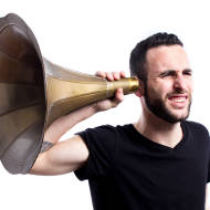 Man tries to hear with old-fashioned hearing aid. (Photo: Axel Alvarez/Shutterstock)