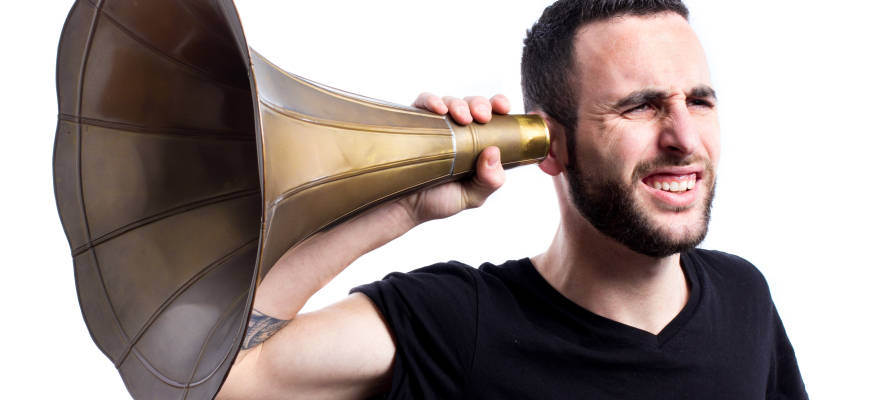 Man tries to hear with old-fashioned hearing aid. (Photo: Axel Alvarez/Shutterstock)