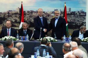 Palestinian Prime Minister Rami Hamdallah shakes hands with senior Hamas leader Ismail Haniyeh in October 2014.