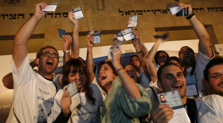 Young French adults hold up their new Israeli Id's after emigrating to Israel.