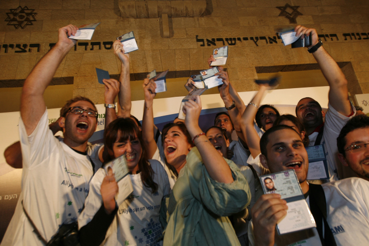 Young French adults hold up their new Israeli Id's after emigrating to Israel.