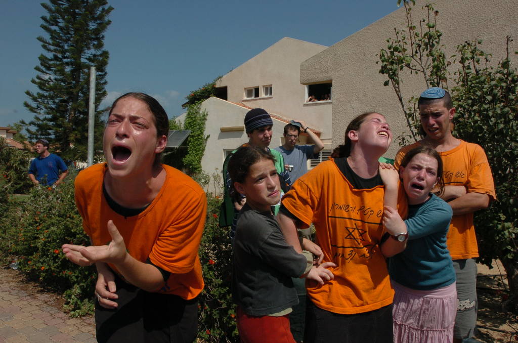 Jewish settlers cry as a soldier forces them to evacuate their home in the Jewish settlement of Neve Dekalim. Photo by Flash90