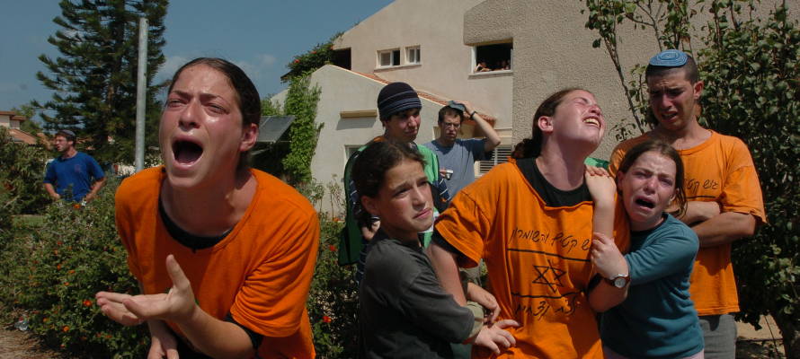 Jewish settlers cry as a soldier forces them to evacuate their home in the Jewish settlement of Neve Dekalim. Photo by Flash90