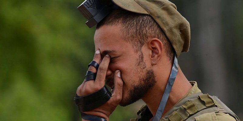 Israeli soldier praying wearing tefillin