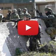 IDF soldiers take positions during a raid to arrest a Palestinian