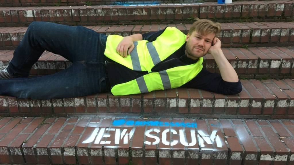 Berlin-based Israeli artist Shahak Shapira posing in front of his protest art in Hamburg, Germany. (Photo: Shahak Shapira)