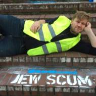 Berlin-based Israeli artist Shahak Shapira posing in front of his protest art in Hamburg, Germany. (Photo: Shahak Shapira)