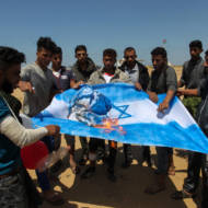 Palestinians burn an Israeli flag near the Gaza border. (Abed Rahim Khatib/Flash90)