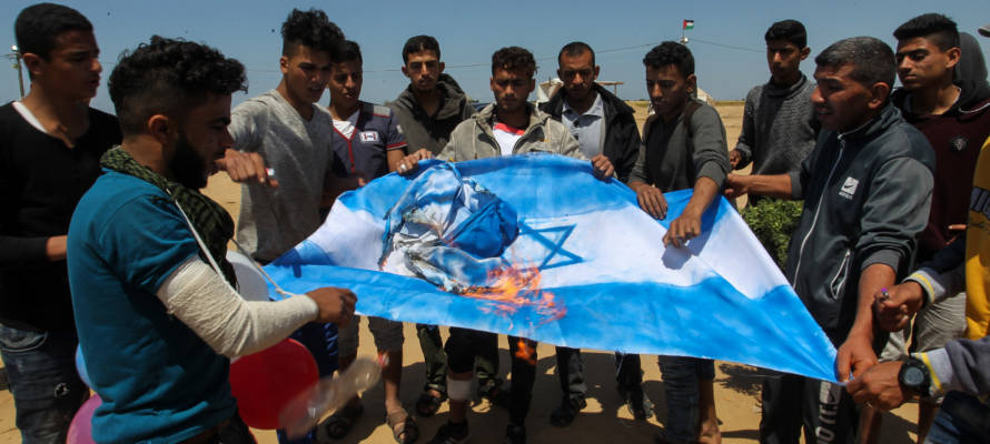 Palestinians burn an Israeli flag near the Gaza border. (Abed Rahim Khatib/Flash90)