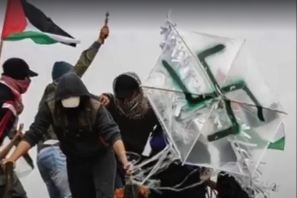 Palestinian rioters in Gaza with a swastika-adorned arson. (screenshot)
