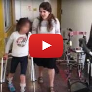 A National Civil Service volunteer helps a disabled child. (Screenshot)