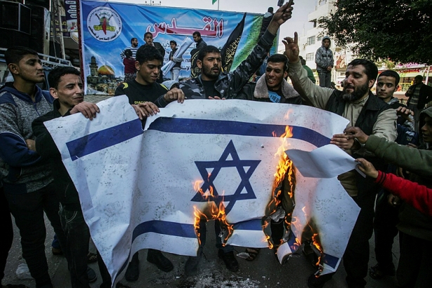 Palestinians burn an Israeli flag