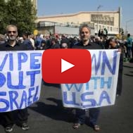 Two Iranians hold anti-US and anti-Israeli placards
