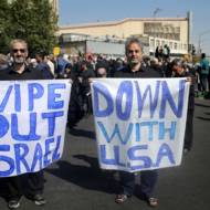 Two Iranians hold anti-US and anti-Israeli placards