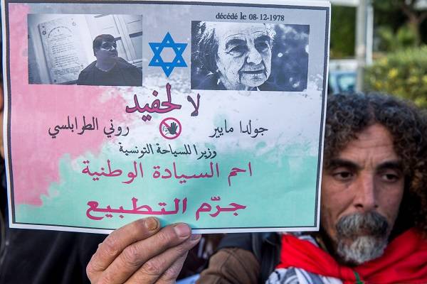 A an anti-Israel Tunisian protester at the office of the nation's only Jewish cabinet member. (AP Photo/Hassene Dridi)