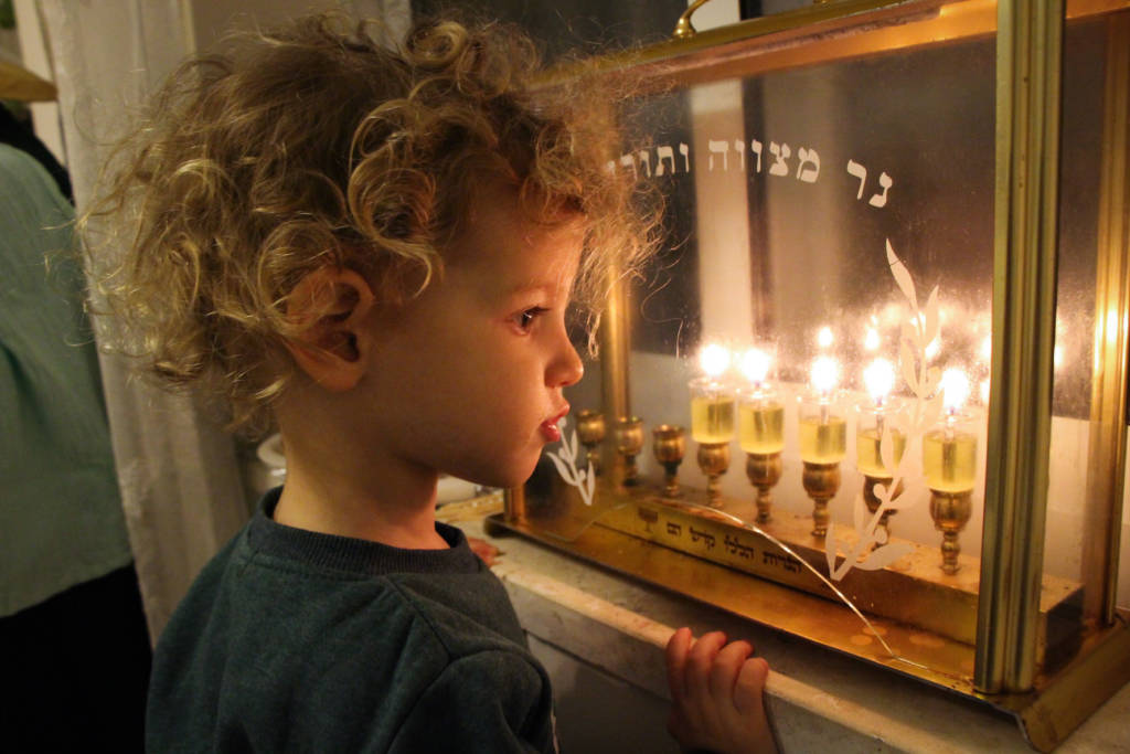 An Israeli boy looking at Chanukah candles. (Gershon Elinson/Flash90)
