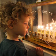An Israeli boy looking at Chanukah candles. (Gershon Elinson/Flash90)