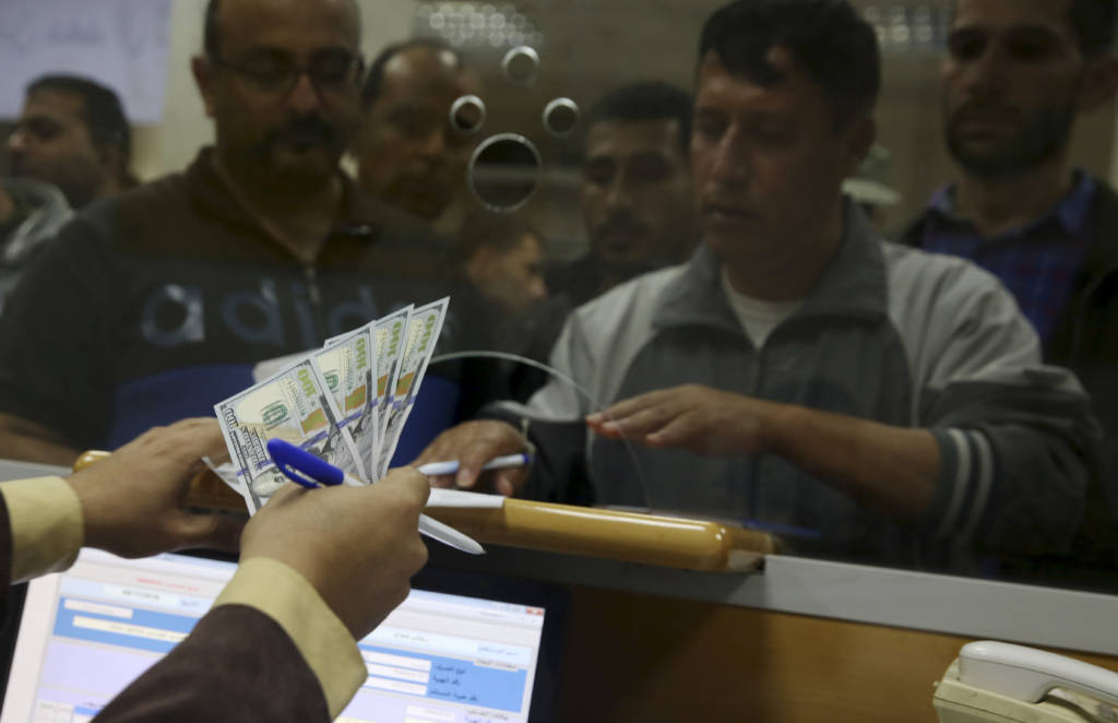 An employee of the Hamas terror group receives a salary payment financed by millions of dollars in aid from Qatar. (AP Photo/Adel Hana)