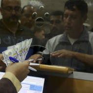An employee of the Hamas terror group receives a salary payment  financed by millions of dollars in aid from Qatar. (AP Photo/Adel Hana)