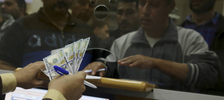 An employee of the Hamas terror group receives a salary payment financed by millions of dollars in aid from Qatar. (AP Photo/Adel Hana)