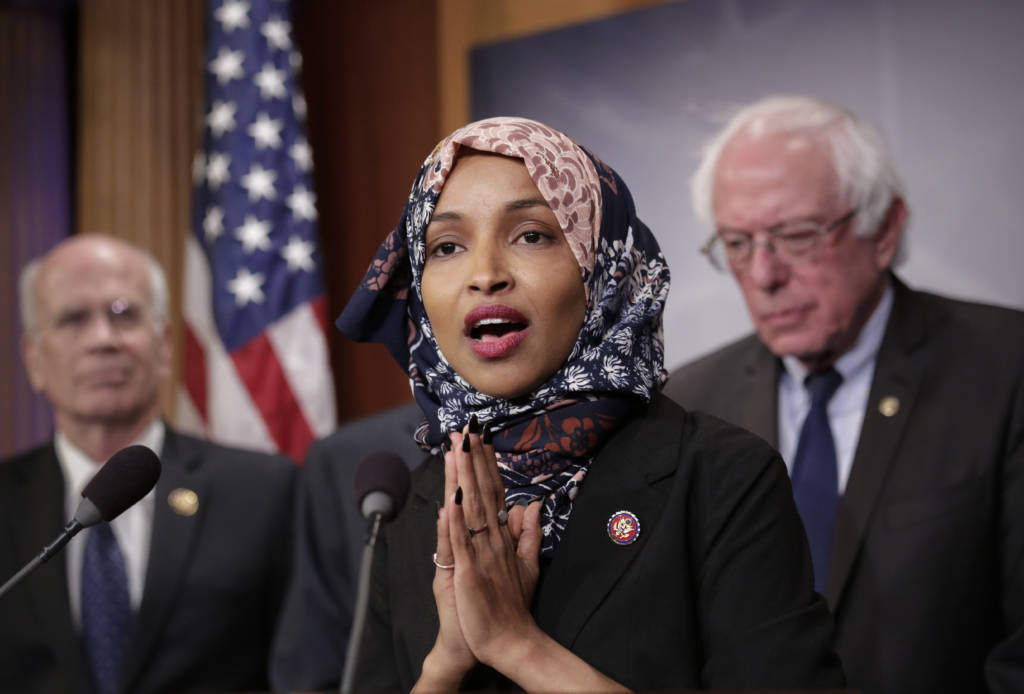 Freshman Rep. Ilhan Omar, D-Minn., center, joins Rep. Peter Welch, D-Vt., left, and Sen. Bernie Sanders, I-Vt. (AP Photo/J. Scott Applewhite)