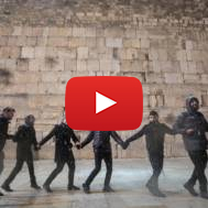 Men dance in the snow at the Western Wal, in Jerusalem. (Noam Rivkin Fenton/Flash90)