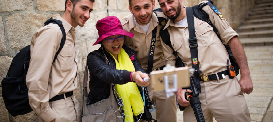 A tourist seen taking selfies with soldiers in Jerusalem's Old City. (Corinna Kern/FLASH90)