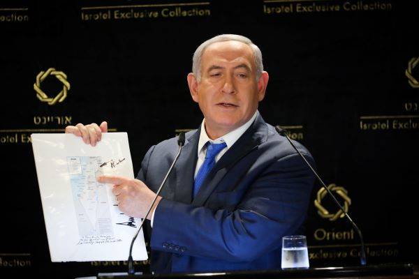 Israeli PM Benjamin Netanyahu with a map from President Donald Trump. (Noam Revkin Fenton/Flash90)