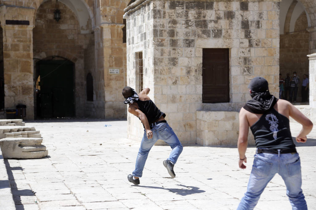 Palestinians throw stones at Israelis on the Temple Mount in a previous clash. (illustrative) (Sliman Khader/Flash 90)