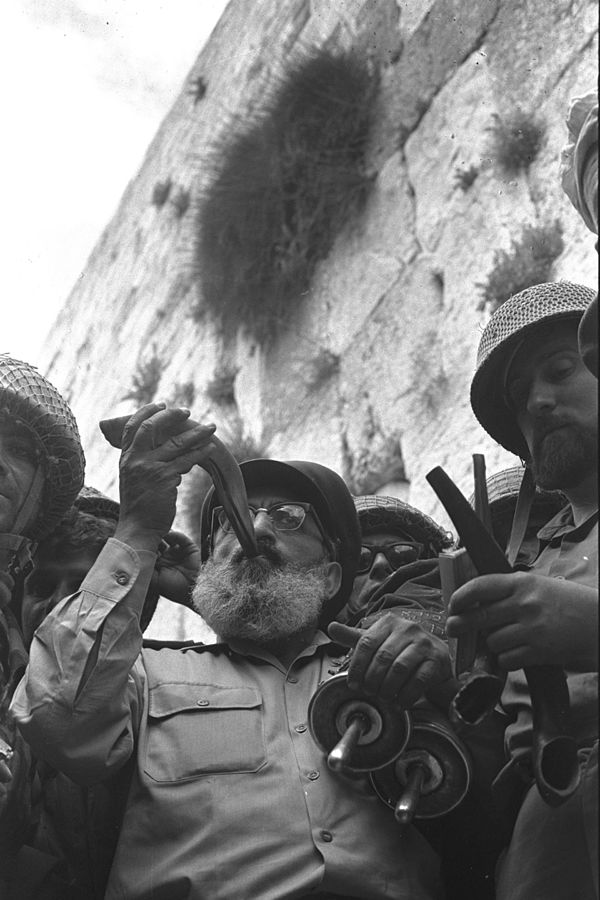 Six Day War. Army chief chaplain Rabbi Shlomo Goren, who is surrounded by IDF soldiers, blows the shofar in front of the Western Wall in Jerusalem. June 1967 (Wikimedia)