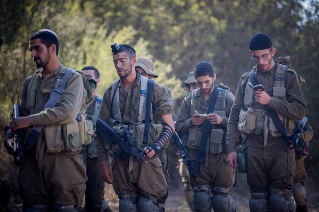 Religious IDF soldiers pray during training.