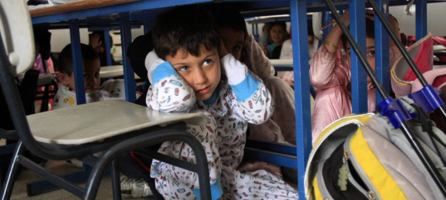 At a school in Ashkelon, children hide under chairs and tables while practicing what to do during an eventual Qassam Rocket attack. (Edi Israel/Flash90)