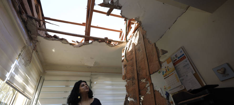 A woman looks at the damage to a house in Sderot, Israel, after it was hit by a rocket fired from Gaza Strip, Nov. 12, 2019.