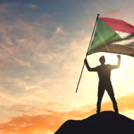 Man waving Sudanese flag (Shutterstock)