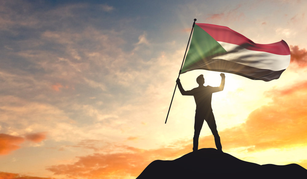 Man waving Sudanese flag (Shutterstock)