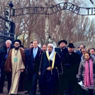 Secretary General of the Muslim World League Dr. Mohammad Al-Issa, center, wearing a white head-covering, and AJC CEO David Harris, next to him, left, lead delegation entering through the Auschwitz gate at the start of a historic visit to the Nazi death camp, Jan. 23, 2020.