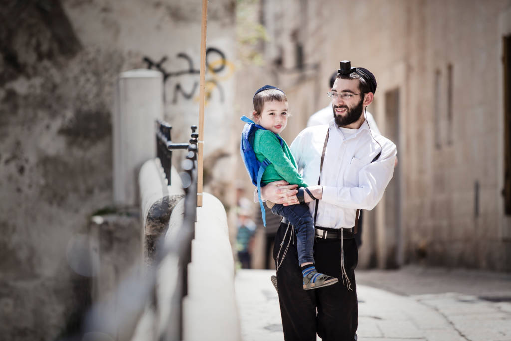 Jewish father carries his son.