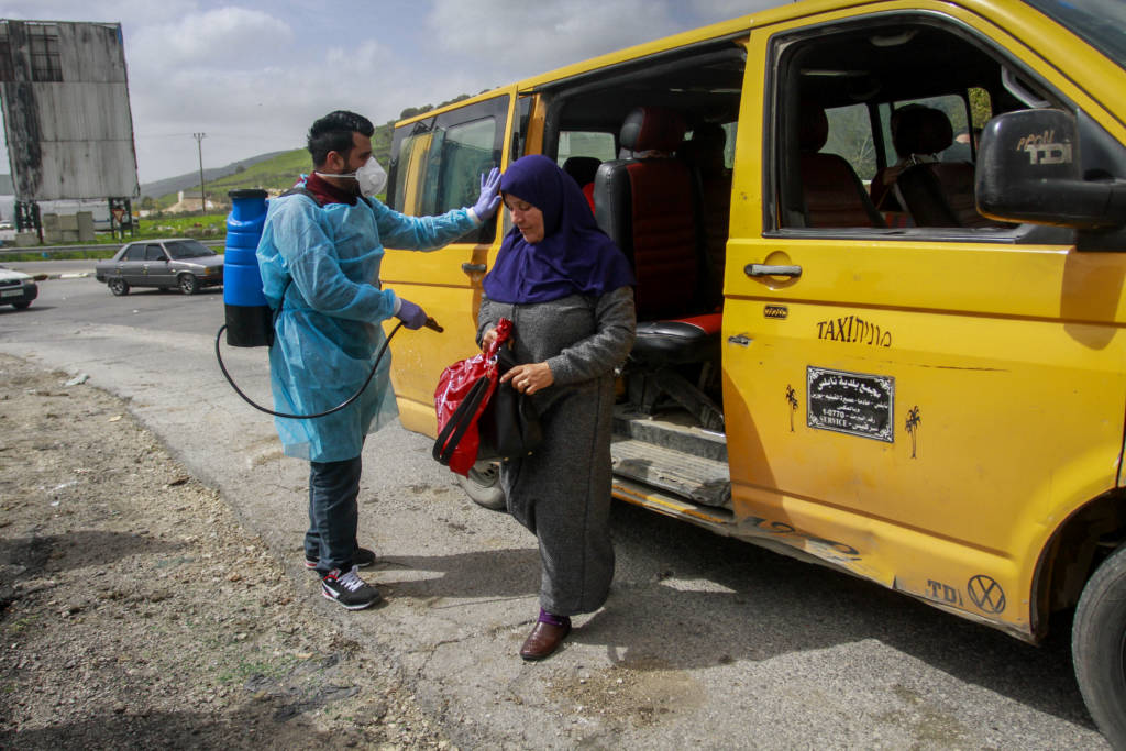 Palestinians disinfect a taxi