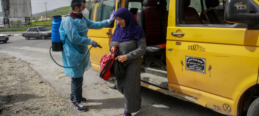 Palestinians disinfect a taxi