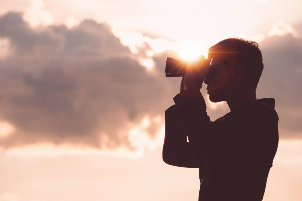 man looking through binoculars